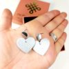 boucles d'oreilles dans une main en forme de cœur cuir argenté