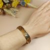 bracelet manchette jonc doré en cuir imitation serpent sur poignet femme