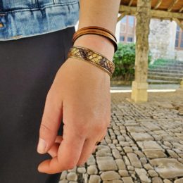 bracelets jonc imitation serpent et bracelet multirang beige portés au poignet d'une femme