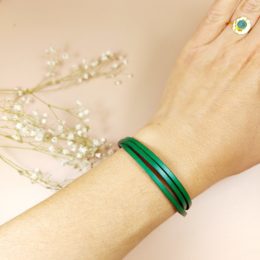 bracelet multirang en cuir fin vert porté au poignet d'une femme