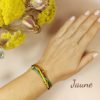 Bracelet 3 lanières de cuir jaune cuivre et vert porté au poignet d'une femme