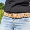 Ceinture large maillons beige en cuir portée sur un jean