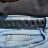 Ceinture fine en cuir noir à maillons portée sur un jean