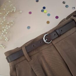 Ceinture fine en cuir marron 2 cm portée dans les passants d'un pantalon camel