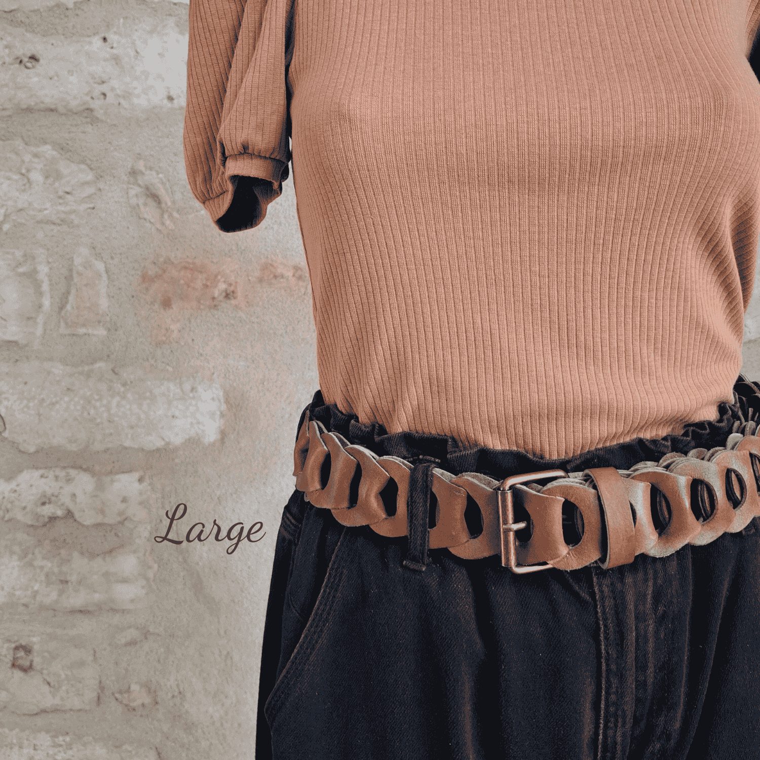 Ceinture tressée en cuir beige camel enfilée sur pantalon - large